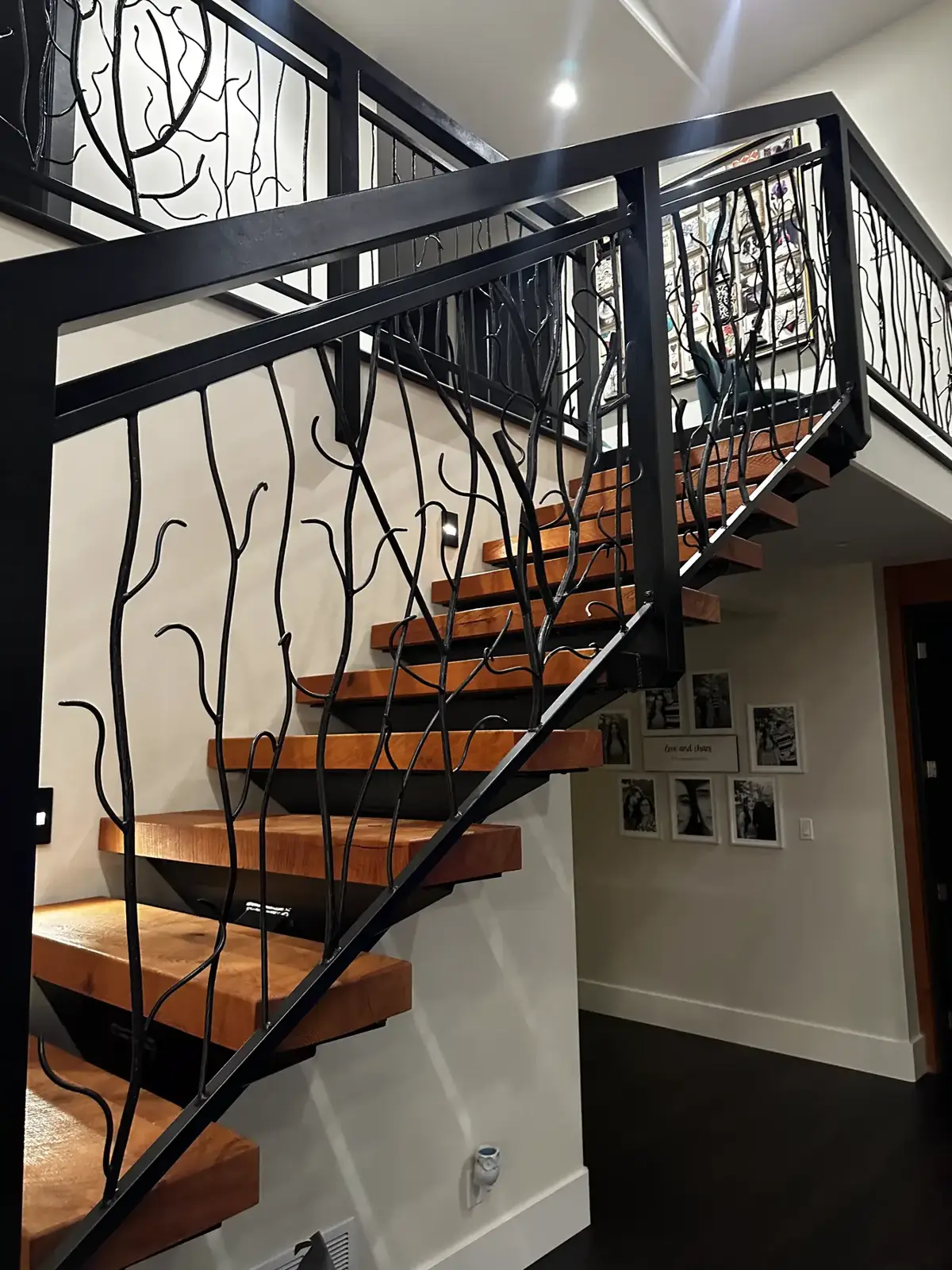 Open-riser stair with a hand-shaped steel branch railing by Wroughtenart